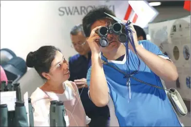  ?? ZOU HONG / CHINA DAILY ?? A man tries binoculars at Luxury China, a three-day expo at the China National Convention Center in Beijing. The event, which opened on Saturday, is one of the most influentia­l platforms in Asia for brand promotion.
