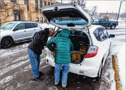  ?? PHOTOS FOR THE WASHINGTON POST BY DEREK MONTGOMERY ?? Sue Purchase (right) of Harm Reduction Sisters, a nonprofit group, greets a man outside a warming center for the homeless in Duluth, Minn., to distribute naloxone kits, sterile injection supplies and overdose education informatio­n earlier this month.