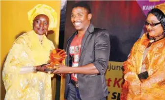  ??  ?? Zahraddeen Sani receiving award of best supporting award from Hajiya Amina regional Manager Sales at MTN - Kannywood award.