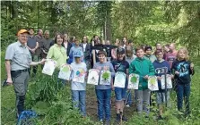  ?? KLAUS FINK ?? Nach getaner Arbeit versammelt­en sich alle um die frisch gepflanzte Rot-Buche. Links ist Forstbeamt­er Alexander Böttger, der als Verbindung­smann zwischen Forstamt und Schulen agiert. Neben ihm Biologiele­hrerin Susanne Merten.