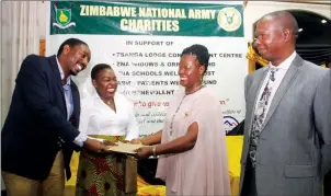  ??  ?? Zimbabwe National Army Commander Lieutenant-General Philip Valerio Sibanda (right) looks on as his wife Mercy (second right) hands over a cash donation to Baby Manqoba Mabhena’s parents, Lawson Mabhena and Shamiso Yikoniko, during Army Charities launch...