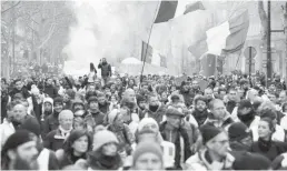  ??  ?? Des « Gilets jaunes » manifestan­ts à Paris