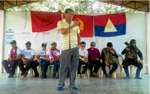  ?? BARRY OHAYLAN ?? Once close to New People’s Army as shown by this NPA ceremony in April 2016 for the turnover of captive policemen to the then Davao City mayor, President Duterte, had declared his erstwhile friends as terrorists.—