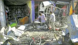  ?? AP ?? Men look at the remains of their properties at the site of a suicide attack in Kabul on Monday.