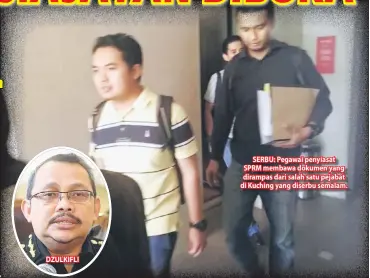  ??  ?? DZULKIFLI SERBU: Pegawai penyiasat SPRM membawa dokumen yang dirampas dari salah satu pejabat di Kuching yang diserbu semalam.