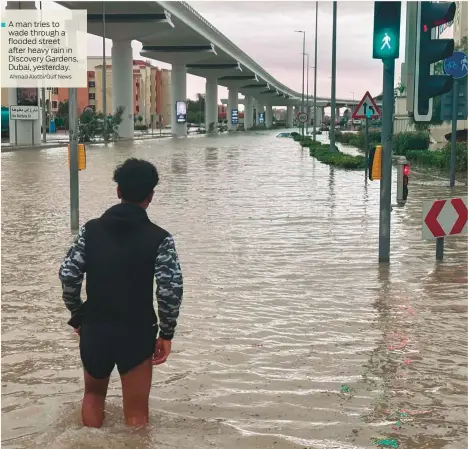  ?? Ahmad Alotbi/Gulf News ?? A man tries to wade through a flooded street after heavy rain in Discovery Gardens, Dubai, yesterday.