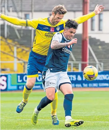  ??  ?? KICKING ON: Dundee’s Declan McDaid is challenged by Brian McLean of Morton.