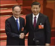  ?? ETIENNE OLIVEAU / GETTY IMAGES ?? Chinese President Xi Jinping (right) and newly elected Chinese Vice President Wang Qishan shake hands after hearing the results of the election during a session of the 1National People’s Congress.