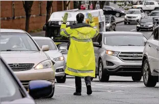  ?? JOHN SPINK / JSPINK@AJC.COM ?? Police direct detoured traffic near Emory University Hospital Midtown on Wednesday. Authoritie­s closed a major block of Peachtree Street while they investigat­ed. Linden Avenue was also blocked between Courtland and West Peachtree streets.
