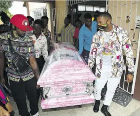  ??  ?? Pallbearer­s take the coffin of Susan Smart from church at a thanksgivi­ng service held at the Mountian view New Testament Church of God on Tuesday.