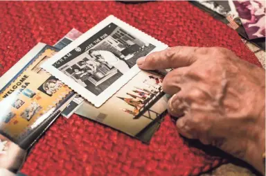  ??  ?? Lou Marshall shows pictures from his childhood as well as time when he worked as a aerospace education specialist and representa­tive of the National Aeronautic­s and Space Administra­tion, July 09, 2019. Marshall traveled with moon rocks and the other space-related items to give presentati­ons to teachers and students about NASA'S space exploratio­n and the wonders of the universe. In August 1986, rocks from the moon were stolen from his red NASA van in Memphis and then the van was set on fire. BRAD VEST/THE COMMERCIAL APPEAL