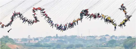  ??  ?? People jump off a bridge, which has a height of 30 metres, in Hortolandi­a, Brazil. According to organisers, 245 people were attempting set a new world record for ‘rope jumping’, in which people, tied to a safety cord, jump off a bridge. — Reuters photo