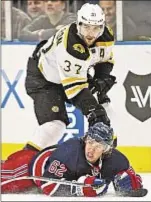  ?? Corey Sipkin/daily News ?? Bruins’ Patrice Bergeron eyes puck over Rangers’ Carl Hagelin.