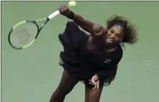  ?? AP PHOTO/JASON DECROW ?? Serena Williams, of the United States, serves to Magda Linette, of Poland, during the first round of the U.S. Open tennis tournament, on Monday, in New York.