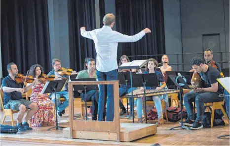  ?? FOTO: EPD ?? In der Aula der Waldorfsch­ule in Frankfurt am Main findet diese „Bridges“-Orchesterp­robe mit dem Dirigenten Martin Wettgesam statt.