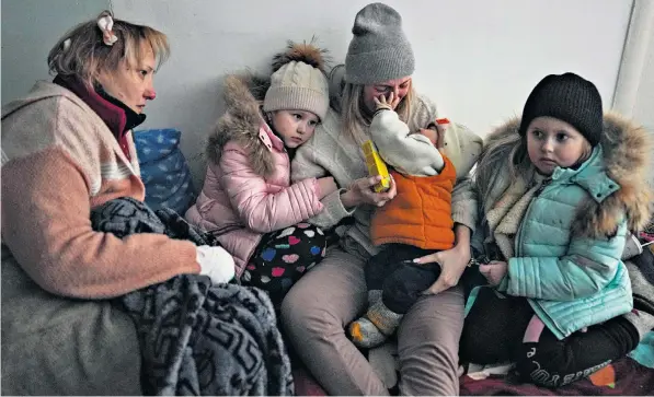  ?? ?? Women and children huddle in the corridor of a hospital in the Ukrainian city of Mariupol, which has been besieged by Russian forces for more than a week