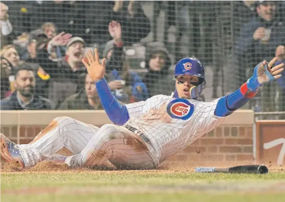  ?? AP ?? Javy Baez scores in the sixth inning Wednesday against the Pirates at Wrigley Field. Baez also hit a three- run home run in the second and a solo shot in the eighth.