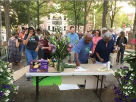  ?? EVAN BRANDT — MEDIANEWS GROUP ?? After some silent prayer/meditation, those at Thursday’s afternoons vigil are invited to write messages on a banner listing mass shootings in 2019.