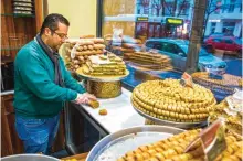  ??  ?? Tamem Al-Sakka is seen working in his pastry shop, "Konditorei Damaskus" in the Neukoeln neighbourh­ood of Berlin. — AFP photos