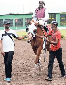  ?? FILE ?? Dane Rambally (left) and Delroy Spencer leading in jockey Shane Ellis aboard ORPHEUS after winning the 21st running of the Sir Howard Stakes at Caymanas Park on Saturday, February 27, 2016.