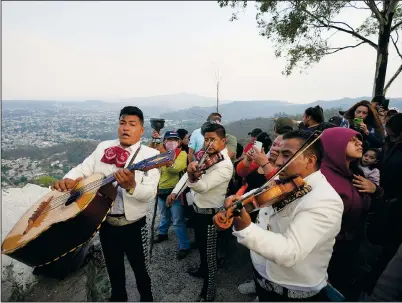  ?? ?? Musicians play Monday under the cross before it is lowered from the hilltop.