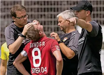  ?? FOTO: IMAGO ?? Schrecksek­unde am Kurtekotte­n: Lars Bender muss seine Platzwunde behandeln lassen. Sein Coach Heiko Herrlich (r.) stellt derweil dirigieren­d die Defensive um. Der Kapitän konnte dann aber schnell wieder zurück auf den Platz.