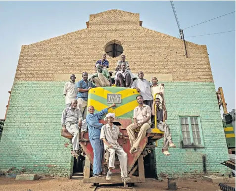  ??  ?? Workers on a train, which is to be refurbishe­d at Atbara, as the World Food Programme aims to throw a lifeline to millions, helping to take food to starving people in Darfur, South Sudan and Tigray