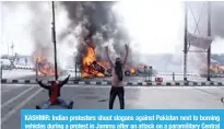  ?? —AFP ?? KASHMIR: Indian protesters shout slogans against Pakistan next to burning vehicles during a protest in Jammu after an attack on a paramilita­ry Central Reserve Police Force (CRPF) convoy in the Lethpora area of Kashmir.