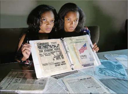  ?? CURTIS COMPTON/CCOMPTON@AJC.COM ?? August 22, 2018 Lawrencevi­lle: Twin sisters Sharena (left) and Malia Johnson, 17, with their civil rights Family Heritage Project they presented as Girl Scouts on Tuesday, August 22, 2018, in Lawrencevi­lle.