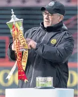  ??  ?? Ian McCall collects the League One Championsh­ip trophy