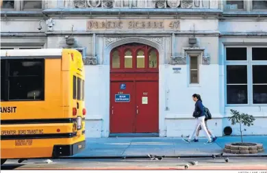  ?? JUSTIN LANE / EFE ?? Dos personas pasan ante una escuela pública, ayer en Nueva York.