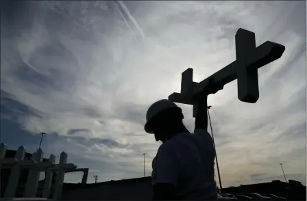  ?? JOHN LOCHER — THE ASSOCIATED PRESS ?? Greg Zanis prepares crosses to place at a makeshift memorial for victims of a mass shooting at a shopping complex Monday in El Paso, Texas.