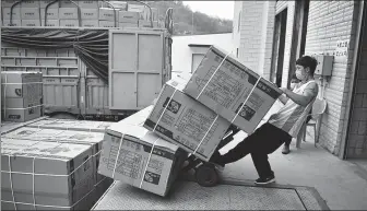  ?? LIU RANYANG / CHINA NEWS SERVICE ?? An employee loads packages for cross-border shipments onto a truck at a warehouse in Hekou, Yunnan province, on March 20.