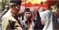  ?? GHINAN SALMAN/JAWA POS RADAR MADURA ?? BELASUNGKA­WA: Mahfud MD (kiri) berbincang dengan istri almarhum Achmad Budi C., Sianit Sinta, di rumah duka, Sampang, kemarin.