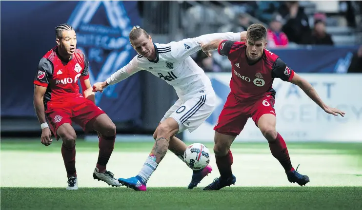  ?? — THE CANADIAN PRESS FILES ?? Vancouver Whitecaps’ Brek Shea, centre, in action against Toronto FC in March, has been making a splash on the pitch as well as the canvas.