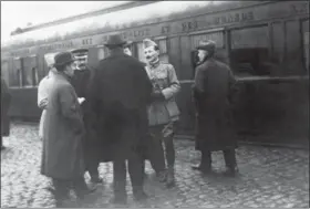  ?? THE ASSOCIATED PRESS ?? In this Nov. 1918 photo, the German and French delegation­s speak as they wait in Rethondes for the start of the train to the Armistice conference in the Forest of Compiegne, France.