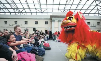  ?? LI YING / XINHUA ?? People watch a traditiona­l Chinese lion dance performanc­e during a Chinese Lunar New Year celebratio­n held at the National Maritime Museum in London on Saturday.