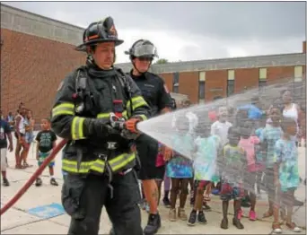  ?? KEVIN TUSTIN — DIGITAL FIRST MEDIA ?? A gaze of cheers and smiles hide behind a shower of water from the hose.