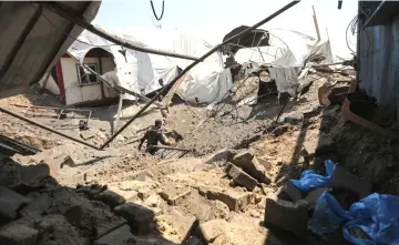  ??  ?? A man inspects the damage at a site targeted by an Israeli airstrike a day before in Khan Younis in the southern Gaza strip. — AFP photos