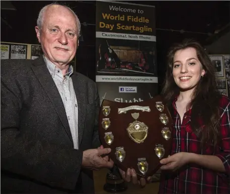  ?? Photo by John Reidy. ?? Aberdeen-bound: Matt Cranitch and Caoimhe Flannery pictured with the original Scartaglin Féile Cheoil Pádraig Ó Caoimh Perpetual Shield, which was won by the late Scartaglin fiddle player, Mikey Duggan, on its first outing in 1967.