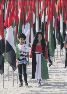  ?? Ruel Pableo for The National ?? A girl and a boy wearing the colours of the UAE flag enjoy National Day at Kite Beach in Dubai