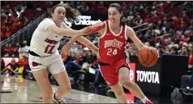  ?? (AP/Timothy D. Easley) ?? Ohio State guard Taylor Mikesell (right) drives to the basket Wednesday past Louisville guard Payton Verhulst during the No. 4 Buckeyes’ 96-77 over the No. 18 Cardinals in Louisville, Ky. Mikesell scored a season-high 26 points in the victory.