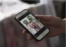  ?? NICK KOZAK/TORONTO STAR ?? Ashley Aseltine shows a photograph of herself from a Zombie Walk to which she wore the wedding dress meant for a wedding that was called off.