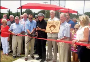  ?? PHOTOS BY DONNA LAMPKIN STEPHENS/CONTRIBUTI­NG PHOTOGRAPH­ER ?? Batesville Mayor Rick Elumbaugh (in sunglasses) assists Terry Sims in cutting the ribbon for the Terry Sims Diamond Sports Complex as friends and family join them. Sims' son, Curt, holds a plaque that was presented to his father.