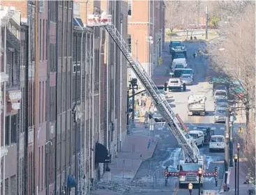  ?? MARKHUMPHR­EY/AP ?? Firefighte­rs in an aerial ladder inspect buildings Monday that were damaged in an explosion Christmas morning in Nashville, Tennessee. Federal officials are trying to piece together the motive behind the bombing.