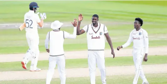  ?? AP ?? West Indies’ captain Jason Holder (second right) celebrates with teammates the dismissal of England’s Dom Sibley (left) during the third day of the third cricket Test match between England and West Indies at Old Trafford in Manchester, England on July 26, 2020.