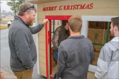  ?? MARK BUFFALO/TRILAKES EDITION ?? Jamie Jones, left, constructi­on technology instructor at Benton High School, gives directions to students Justin Beard, in the doorway, from left, Connor Pinkerton and Carter Wood. The shop class built three vignettes, or small open houses, that will...