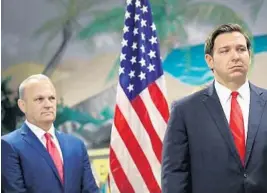  ?? GETTY ?? Florida Education Commission­er Richard Corcoran, left, stands with Gov. Ron DeSantis. He has asked school districts to contact the Department of Education before closing schools or classrooms for COVID-19.