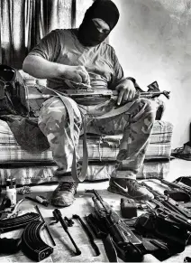  ??  ?? A soldier from the Sinaloa drug cartel cleans guns in the National Geographic documentar­y on migration ‘Blood on the Wall.’