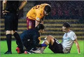  ??  ?? Playmaker Jamie Walker receives treatment after a last-ditch tackle